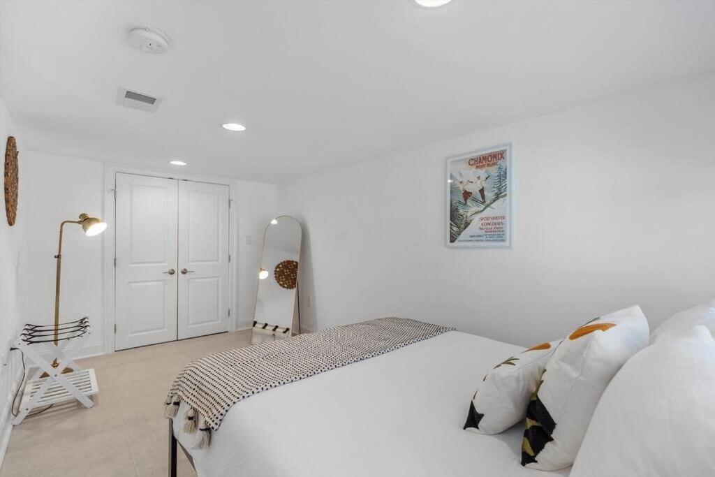 a white bedroom with a large white bed with pillows at Stone's Throw from Capitol Hill Free Parking in Washington, D.C.