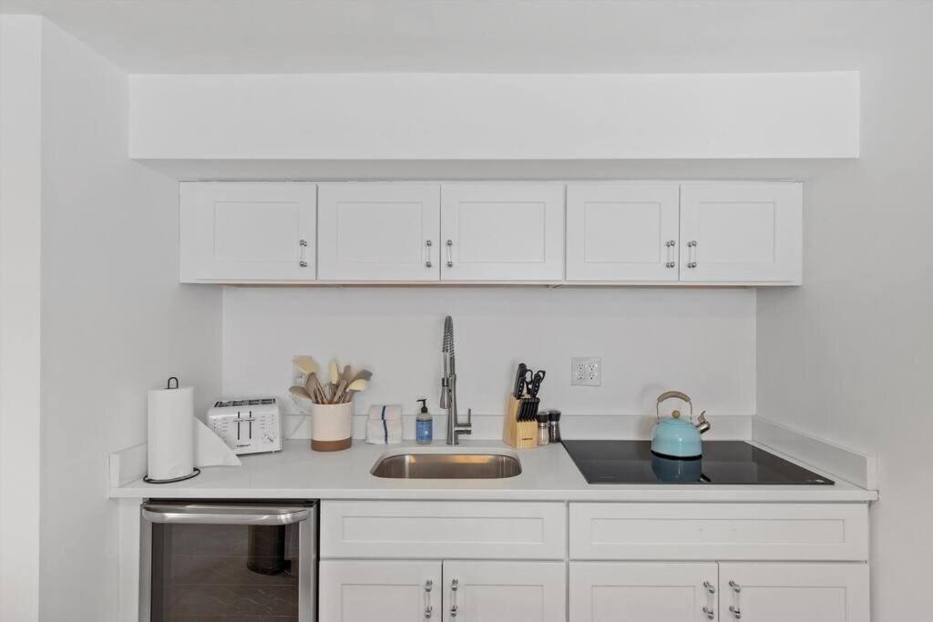 a kitchen with white cabinets and a sink at Stone's Throw from Capitol Hill Free Parking in Washington, D.C.