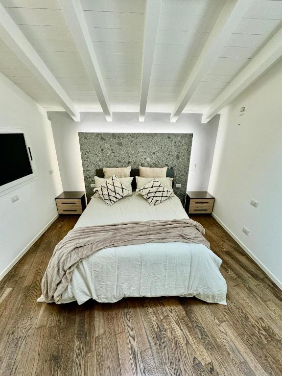 [Bridge Apt.] Garage - Netflix - wifi في بريشيا: غرفة نوم بيضاء مع سرير كبير وتلفزيون بشاشة مسطحة