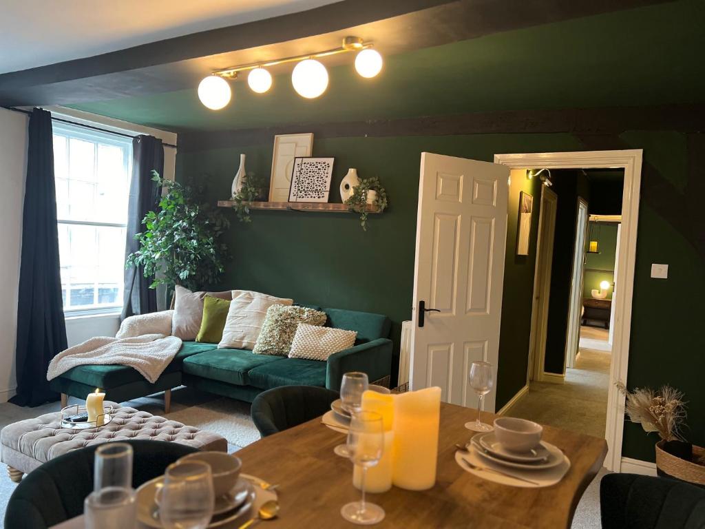 uma sala de estar com um sofá verde e uma mesa em Friar Loft em Worcester