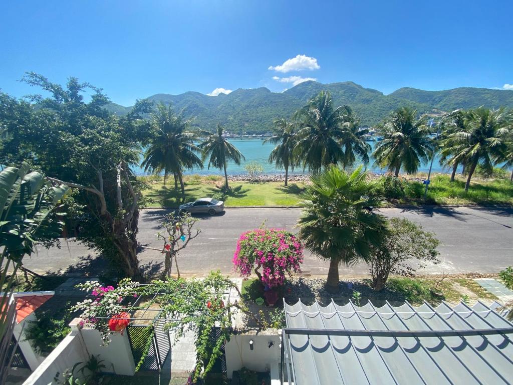 Blick auf einen Parkplatz mit Palmen und das Meer in der Unterkunft M Villa Nha Trang in Nha Trang