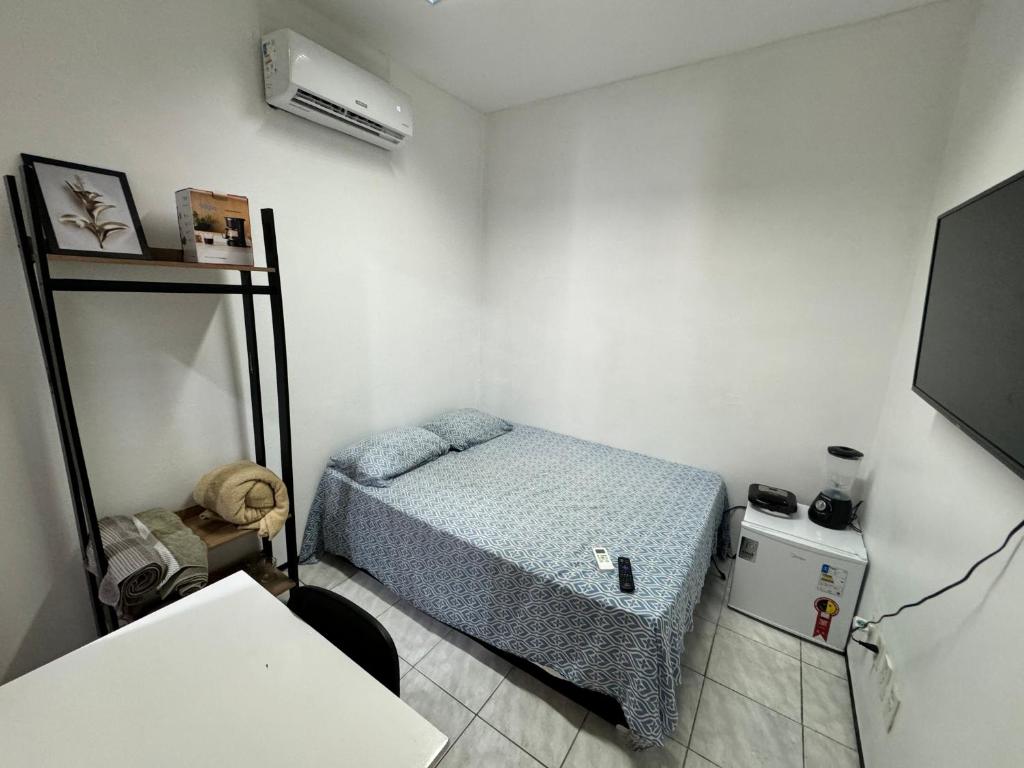 um pequeno quarto com uma cama e ar condicionado em Mini Ap no derby com Garagem em Sobral