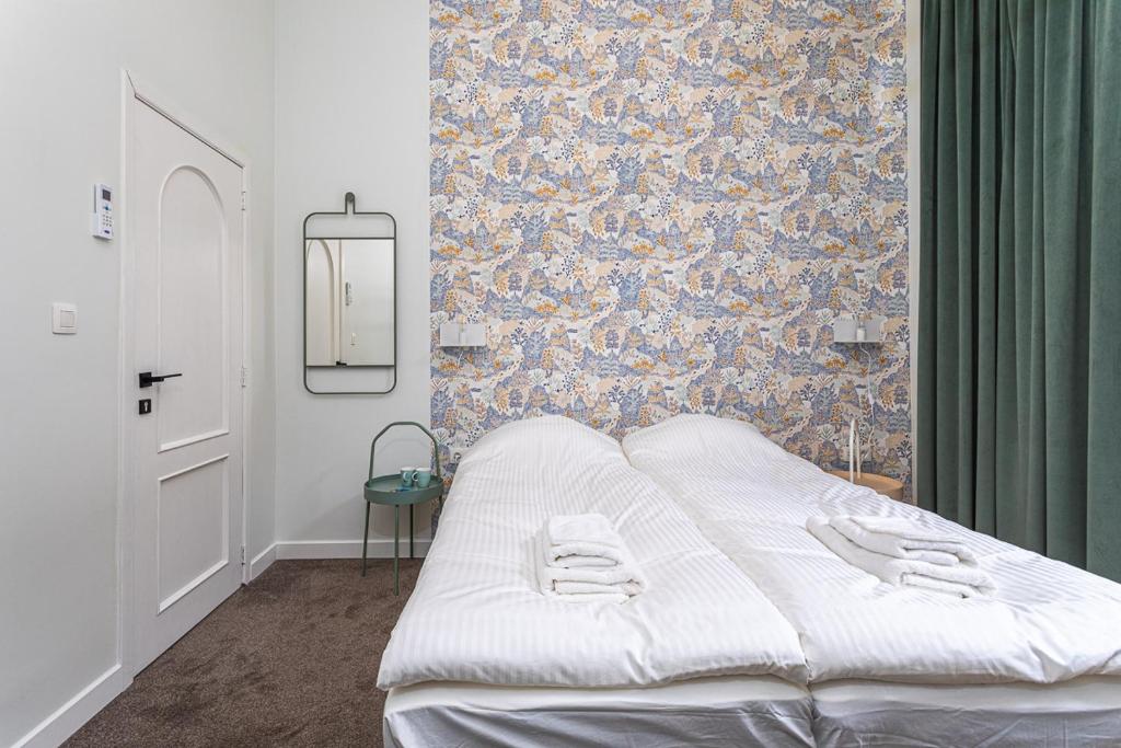 Van Lerius room في أنتويرب: سرير أبيض في غرفة بها جدار