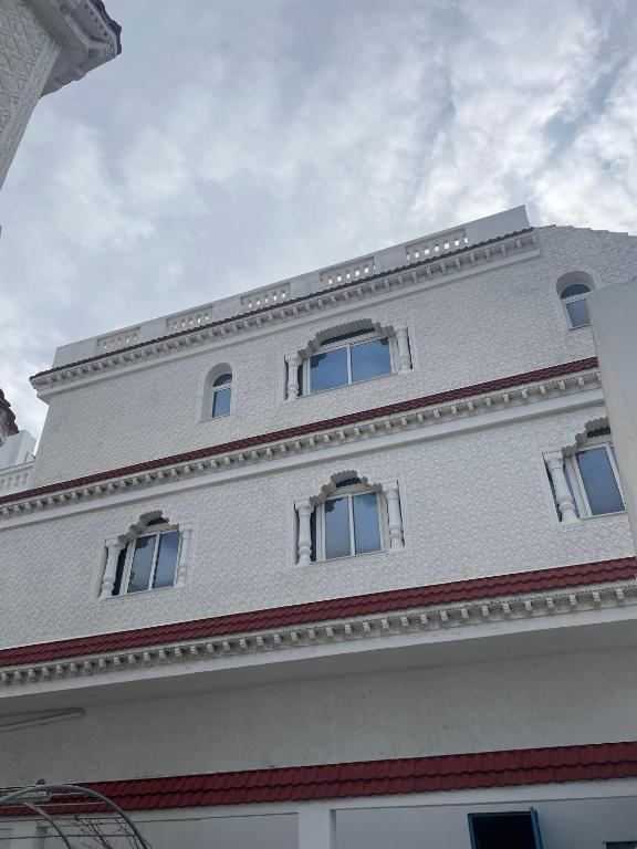 a white building with three windows on top of it at Appartement spacieux, Résidence Les 5 étoiles, Bizerte in Zarzouna