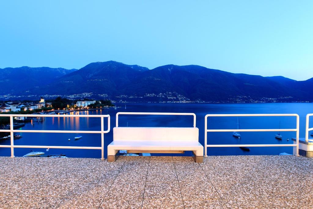 einer weißen Bank, die auf einem Wasserkörper sitzt in der Unterkunft art Ascona Design Attico in Ascona