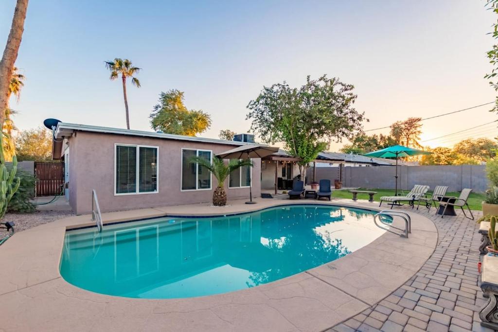 a swimming pool in front of a house at Cozy Tempe Casa with Heated Pool 5 Minutes to ASU in Tempe