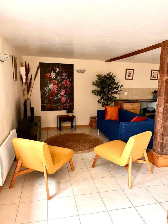 - un salon avec un canapé bleu et des fauteuils jaunes dans l'établissement Le Plantier 1, à Beaulieu-sur-Sonnette