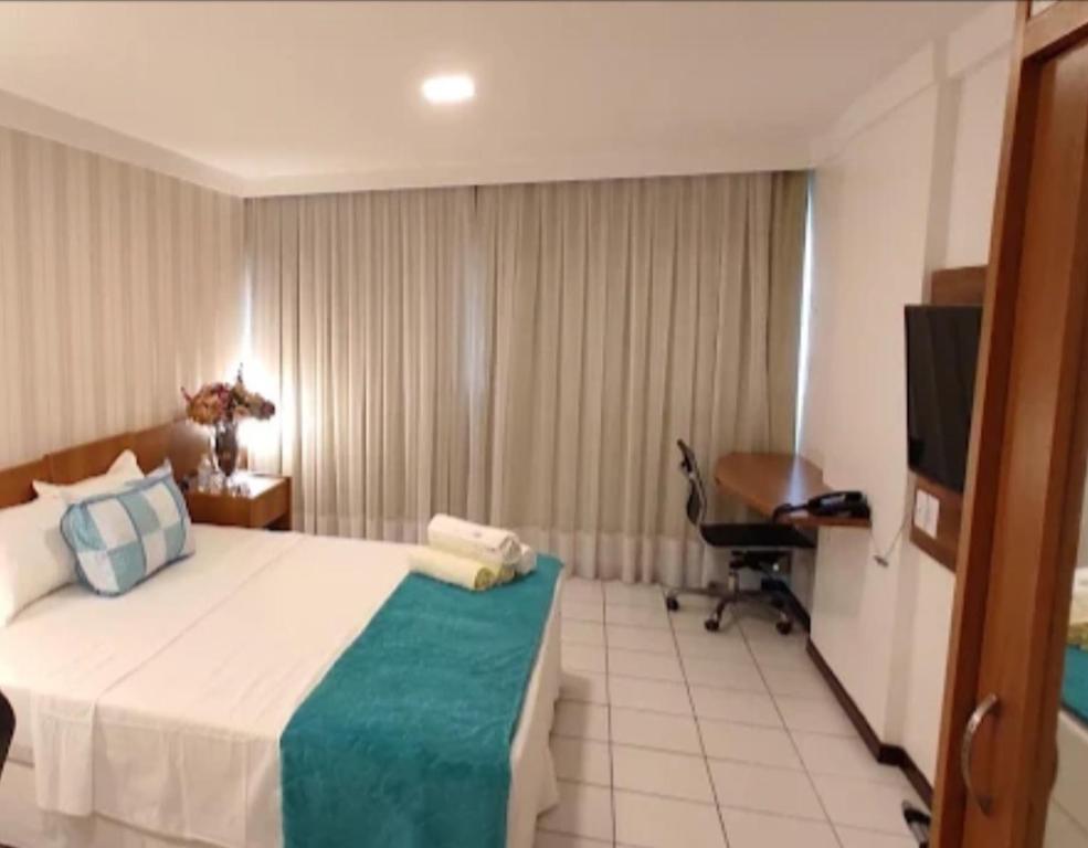 Dormitorio con cama, escritorio y TV en Milor hotel, en Natal
