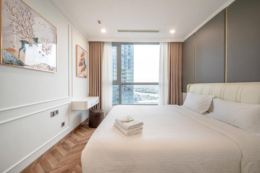 ein Schlafzimmer mit einem großen weißen Bett und einem Fenster in der Unterkunft Landmark 81 SHA PLUS Residence in Ho-Chi-Minh-Stadt