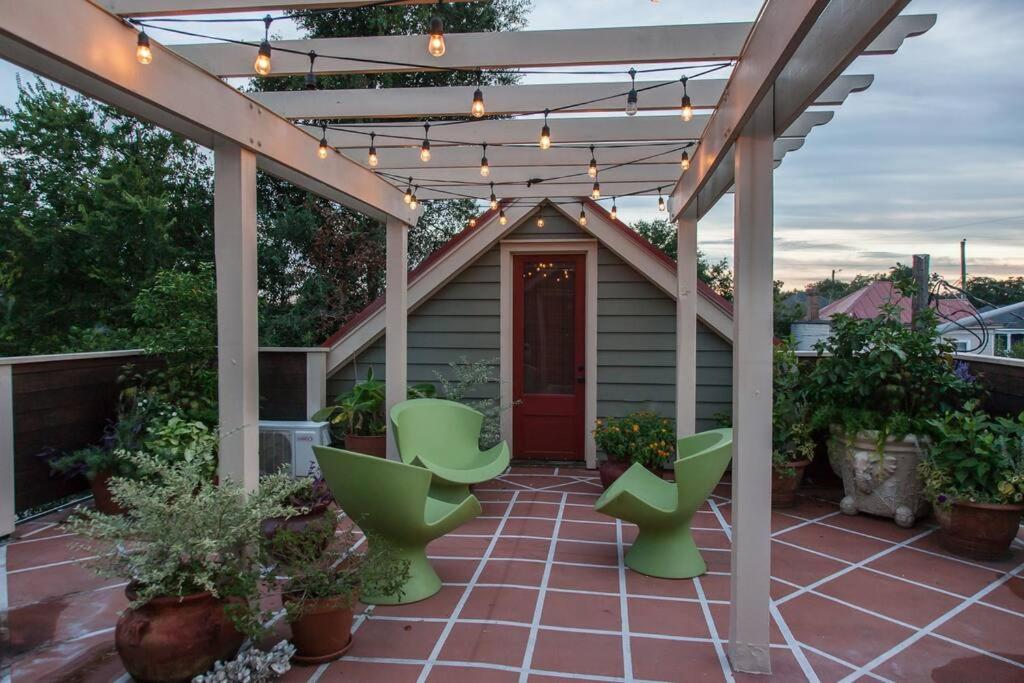a patio with green chairs and a pergola at Roof Terrace Oasis in Savannah