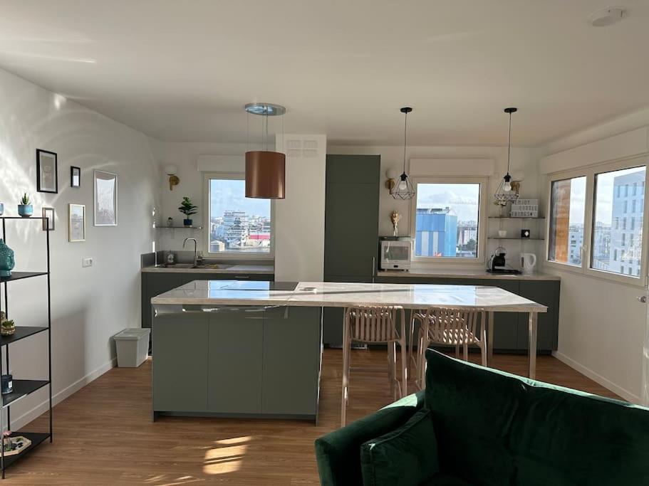 une cuisine et un salon avec une table et des chaises dans l'établissement Appartement spacieux doté d'une grande terrasse, proche Paris. Parking gratuit, à Ivry-sur-Seine