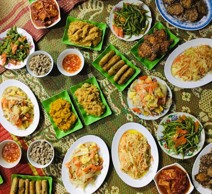 una mesa cubierta con platos de comida y tazones de comida en Wild Flower Homestay, en Ninh Binh