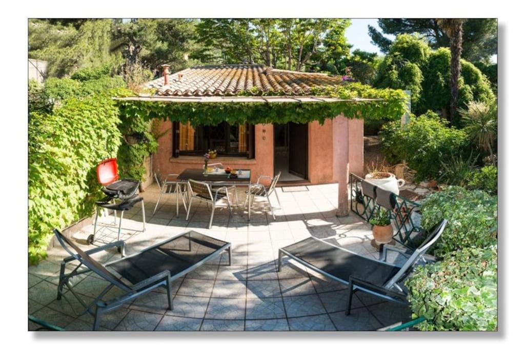 un patio avec des chaises et une table et une maison dans l'établissement Pavillon Saint Clair la campagne au bord de l eau et 2 velos, à Sète