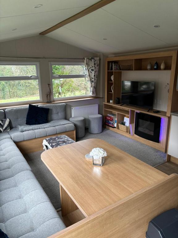 a living room with a couch and a table at 4 Devon Country, Bideford Bay Holiday Park in Bucks Mills