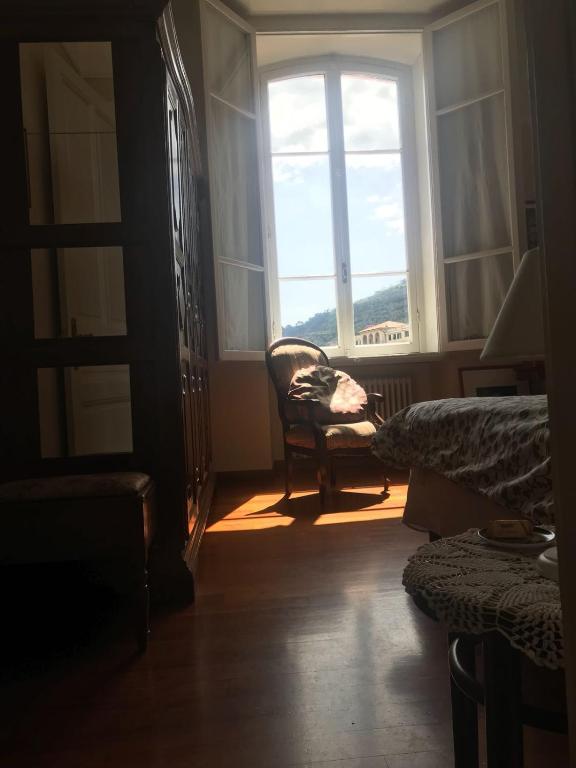 a bedroom with a chair in front of a window at B&B Agapantus in una Villa dell'800 in Dolceacqua
