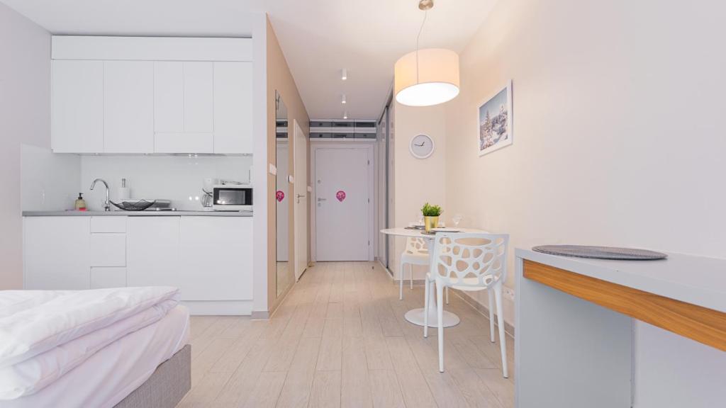 um quarto com uma cama e uma cozinha com uma mesa em VacationClub - STUBAI Apartament 19 em Sienna