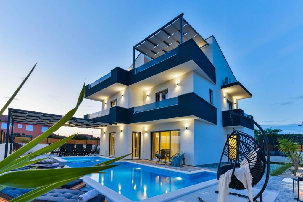 a house with a swimming pool in front of it at Holiday home in Bibinje with sea view, balcony, air conditioning, WiFi 5201-1 in Bibinje