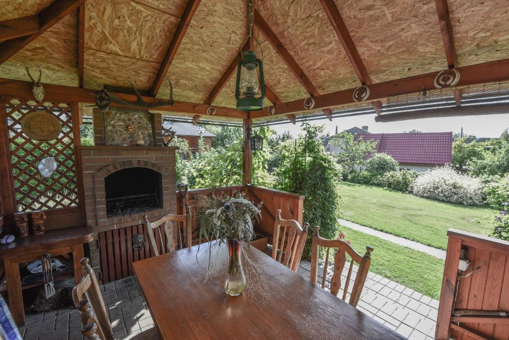 a dining room with a table and a fireplace at Vasarnamis Zarasuose - Vyšnia in Zarasai