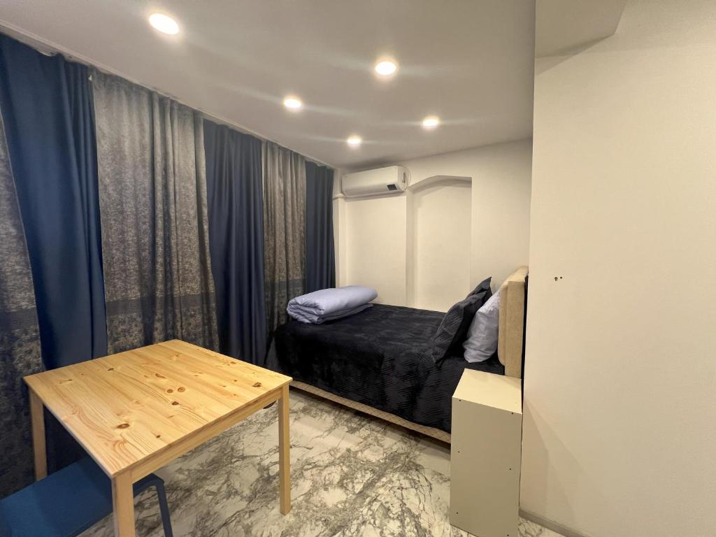 um pequeno quarto com uma cama e uma mesa em Park View 101 em Istambul