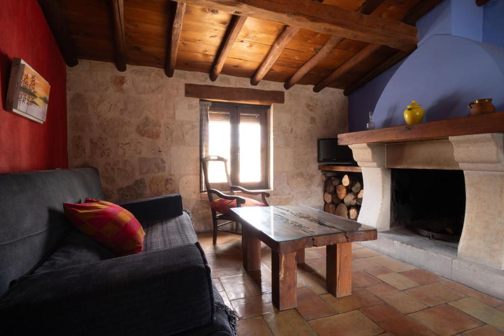 sala de estar con mesa y chimenea en Casa Rural Aldaba, en Alcalá del Júcar