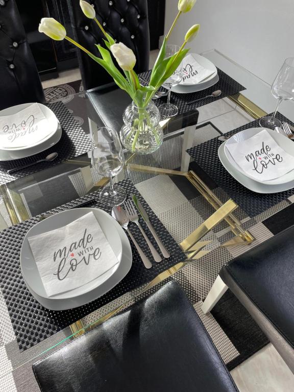 a table with plates and a vase with flowers on it at Noras Ferienwohnung 