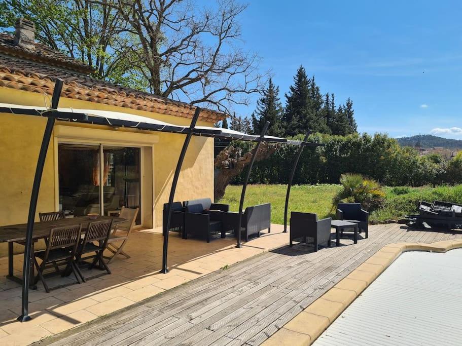 un patio avec une table, des chaises et un barbecue dans l'établissement Belle maison avec piscine, à Le Val