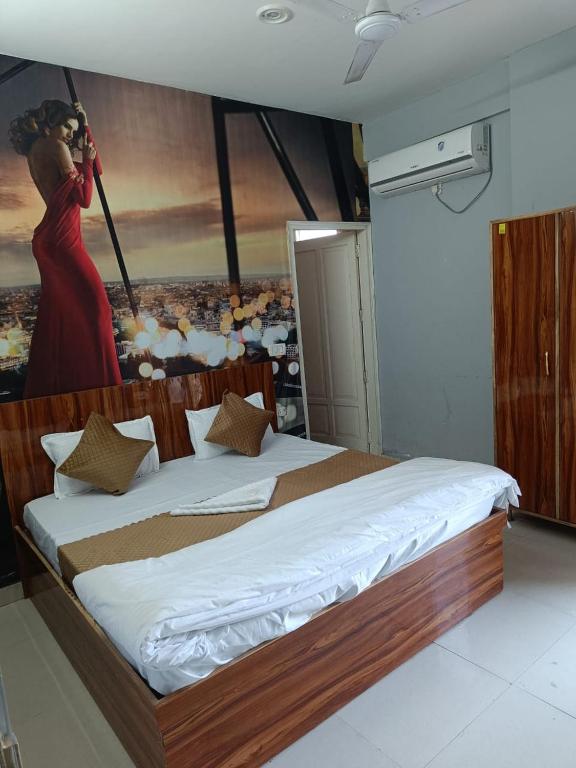 ein Schlafzimmer mit einem großen Bett und einem Gemälde an der Wand in der Unterkunft Royal stay in Dehradun