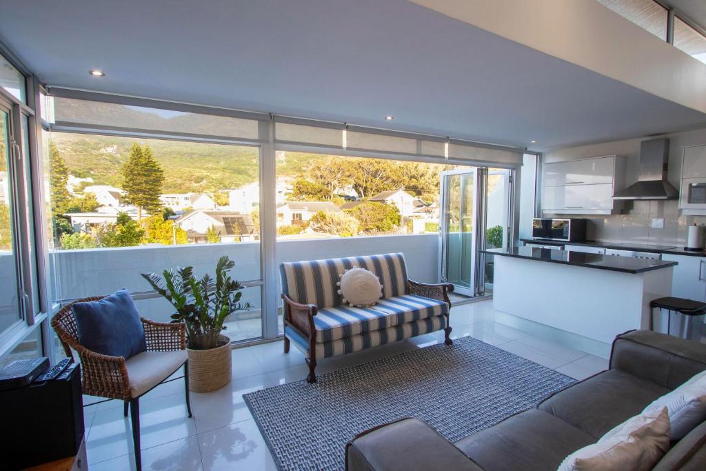 a living room with a couch and a kitchen at Victoria Views in Cape Town