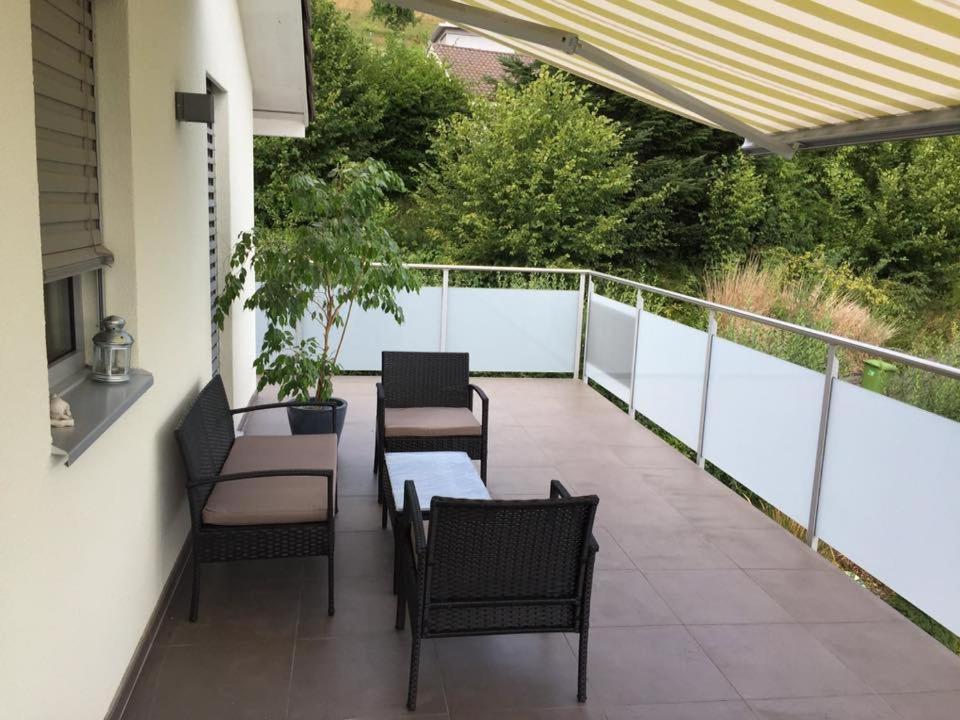 un patio con mesas y sillas en el balcón en Wohnresidenz Casa Fortuna en Suhr