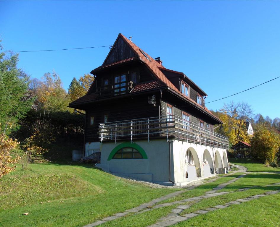 una casa grande con techo de gambrel en un campo en Villa-Bajka, en Wisła