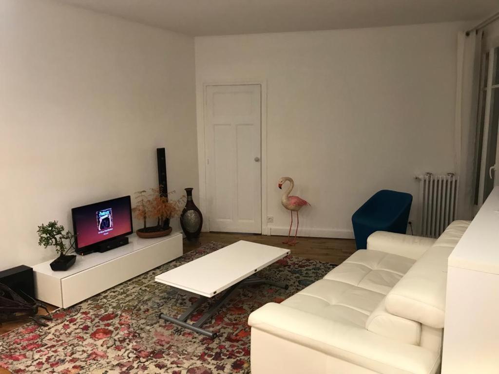 a living room with a white couch and a tv at Cosy Appartement in Paris 15th - Convention Center in Paris