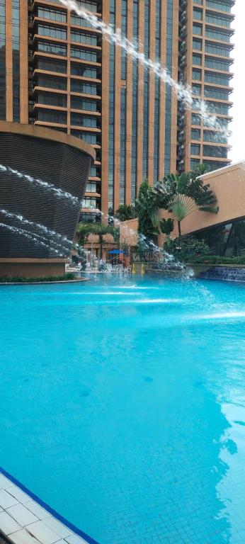 uma grande piscina de água azul em frente aos edifícios em Best Facilities Services Suites At Times Square kl em Kuala Lumpur