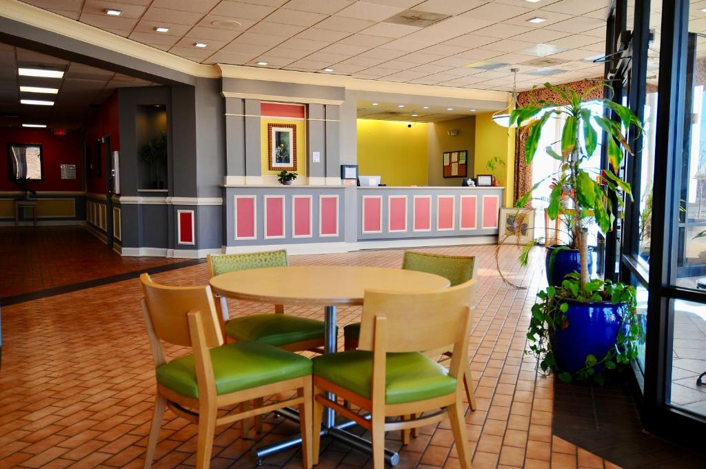 een restaurant met een tafel en stoelen in de lobby bij Madison Inn & Suites in Madison