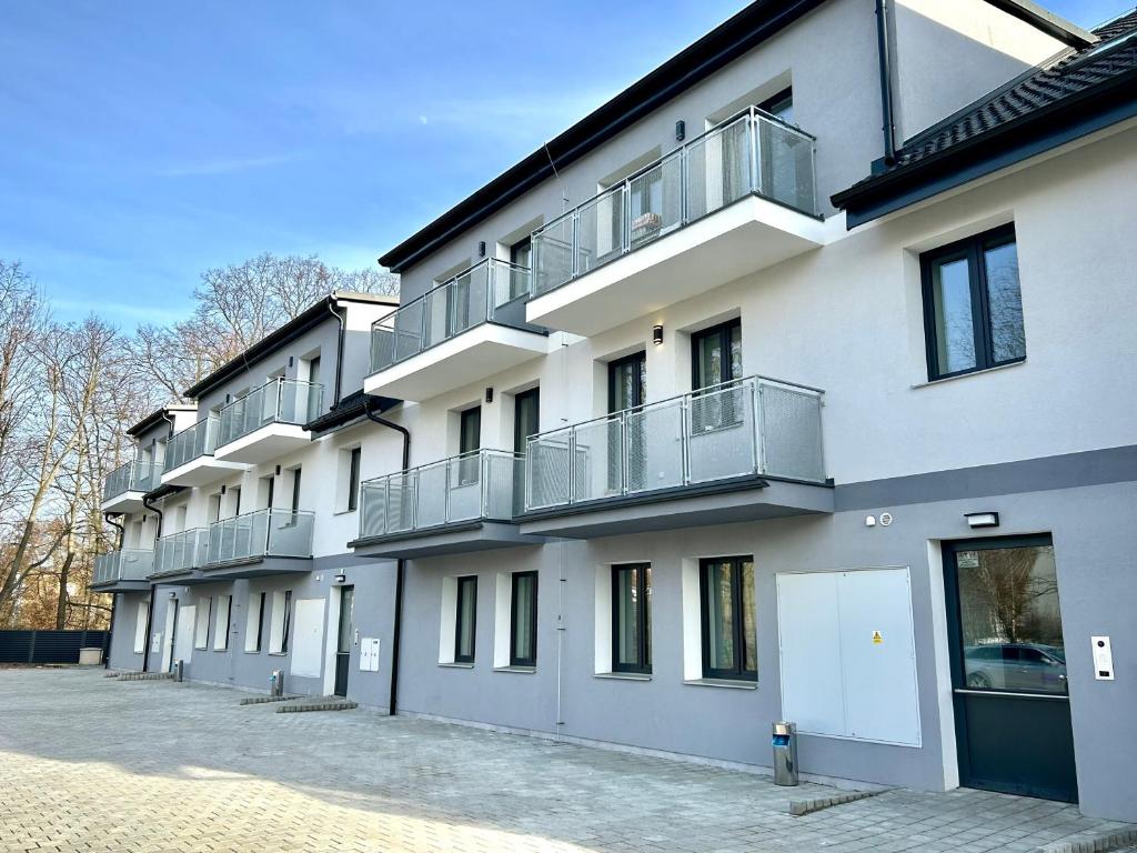 - un bâtiment blanc avec des balcons sur le côté dans l'établissement Apartmány PREMIUM se soukromým parkováním, à Česká Lípa