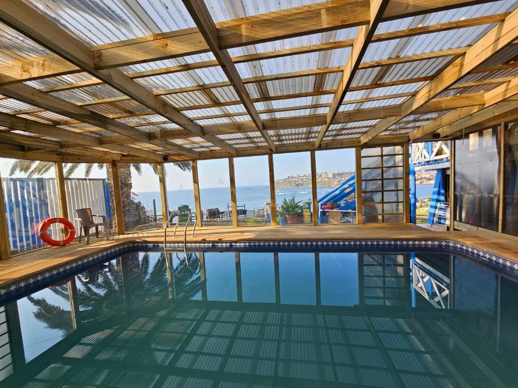 une piscine avec un plafond en bois et une piscine intérieure dans l'établissement Santorini, à Quintero