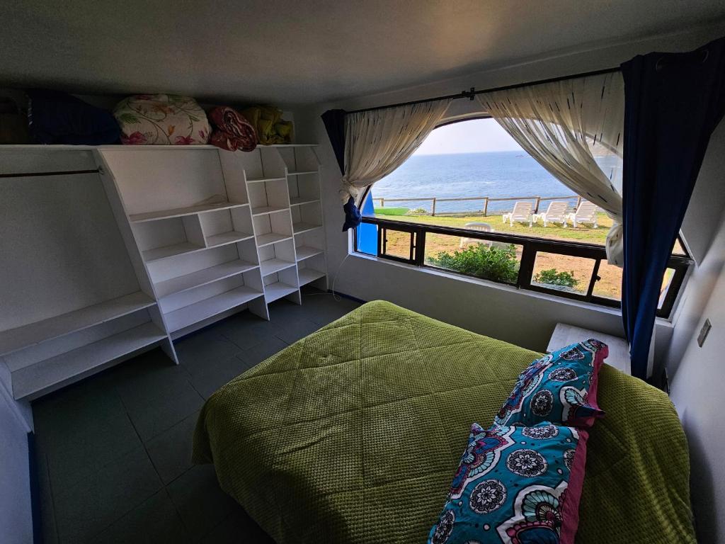 Un dormitorio con una cama y vista al mar. en Santorini, en Quintero