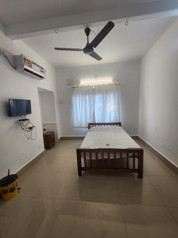 um quarto com uma cama e uma ventoinha de tecto em Holidaze em Alappuzha