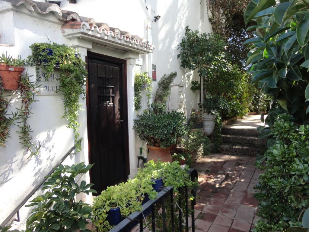 une maison blanche avec une porte noire et quelques plantes dans l'établissement Casa Polo, à Marbella