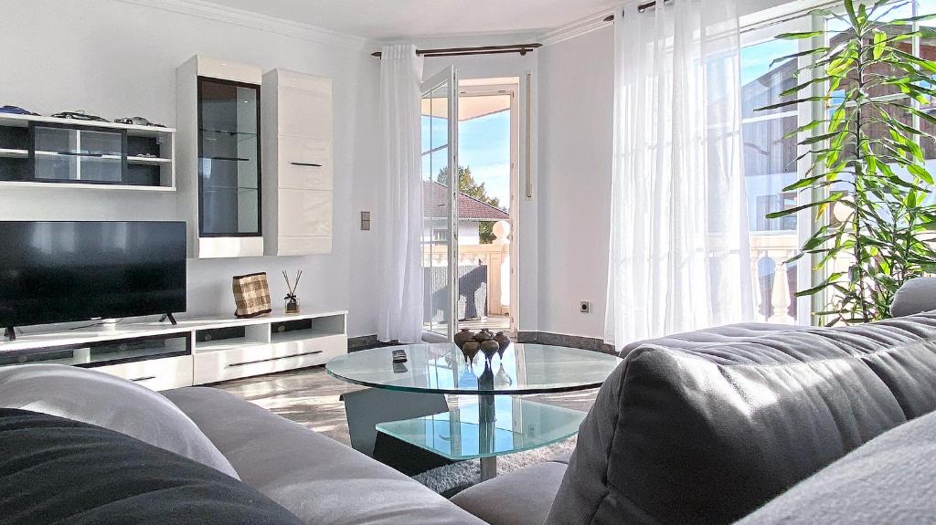 a living room with a couch and a glass table at Elegante Ferienwohnung Relax in Prien am Chiemsee