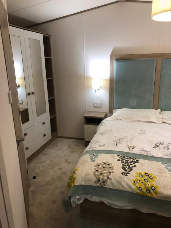 a bedroom with a bed and a dresser and a closet at Lovely Caravan in Turnberry