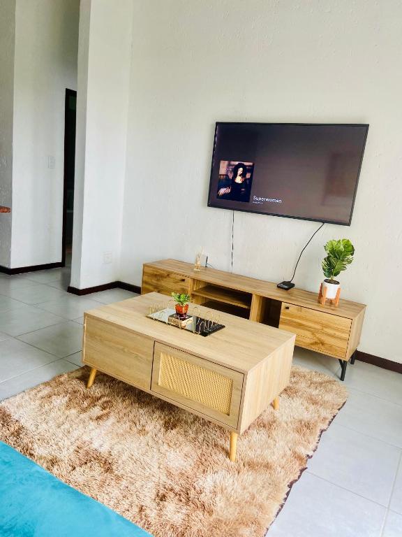 a living room with a coffee table and a flat screen tv at 82 St Andrews Jackal Creek Golf Estate with Backup power & Golf course views in Roodepoort