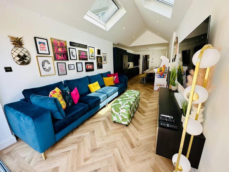 a living room with a blue couch with colorful pillows at Social Central - No 1 for large groups in Cardiff