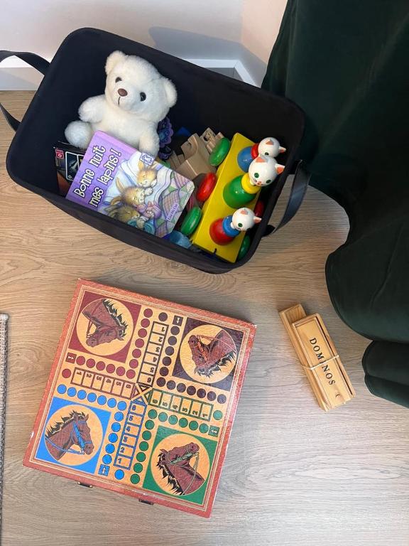 a suitcase filled with toys and a boardgame on a table at Magnifique T2 - proche hyper centre in Toulouse
