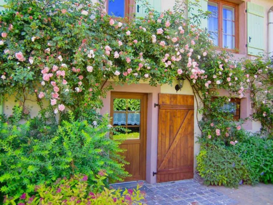 una casa con una puerta cubierta de rosas en Gîte des Grands Clos, en Saint-Amé