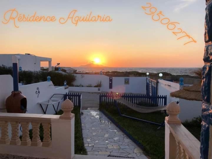 uma vista para o pôr-do-sol a partir de uma varanda de uma casa em Résidence Aquilaria Dar Nouha em El Haouaria