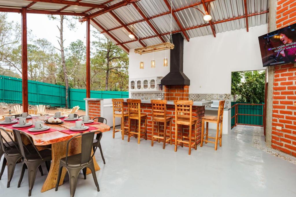 uma área de refeições exterior com mesas e cadeiras de madeira em Entre Pinos em Comayagua
