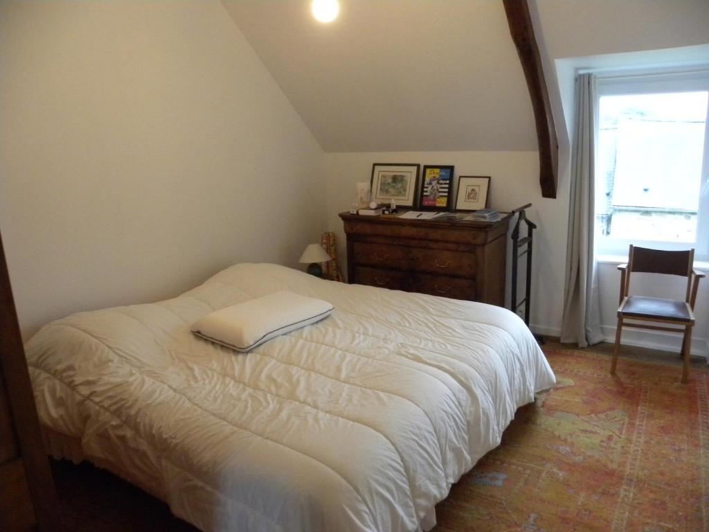 a bedroom with a white bed and a chair at Cap dodo in Plévenon