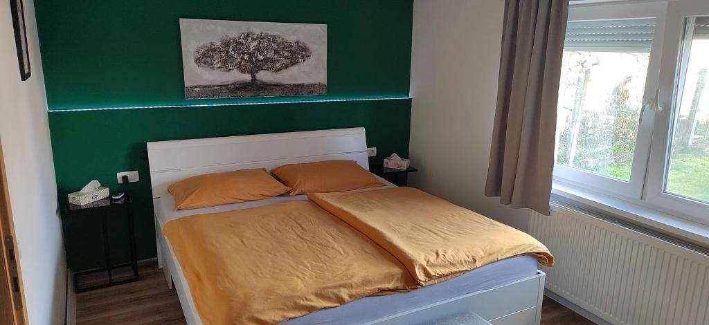 um quarto com uma cama com uma parede verde em Apartman HD em Dakovo