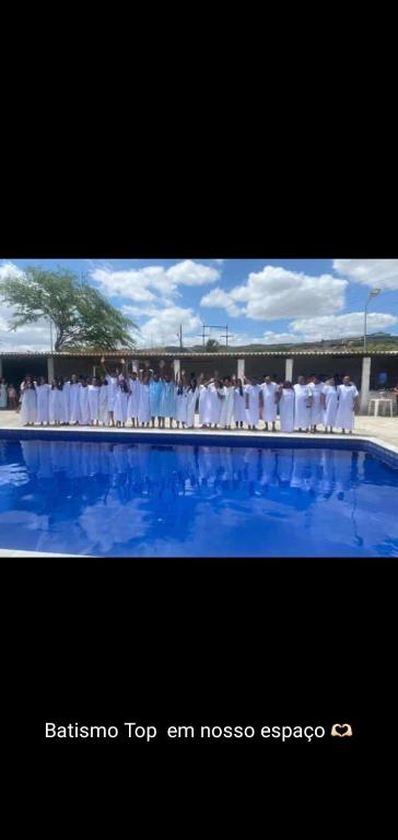 a group of people standing around a swimming pool at Piscina Do Evandro in Campina Grande