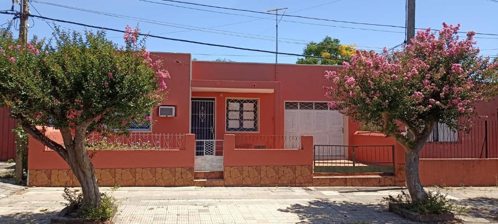 un edificio rojo con dos árboles delante de él en Doña beba en Artigas